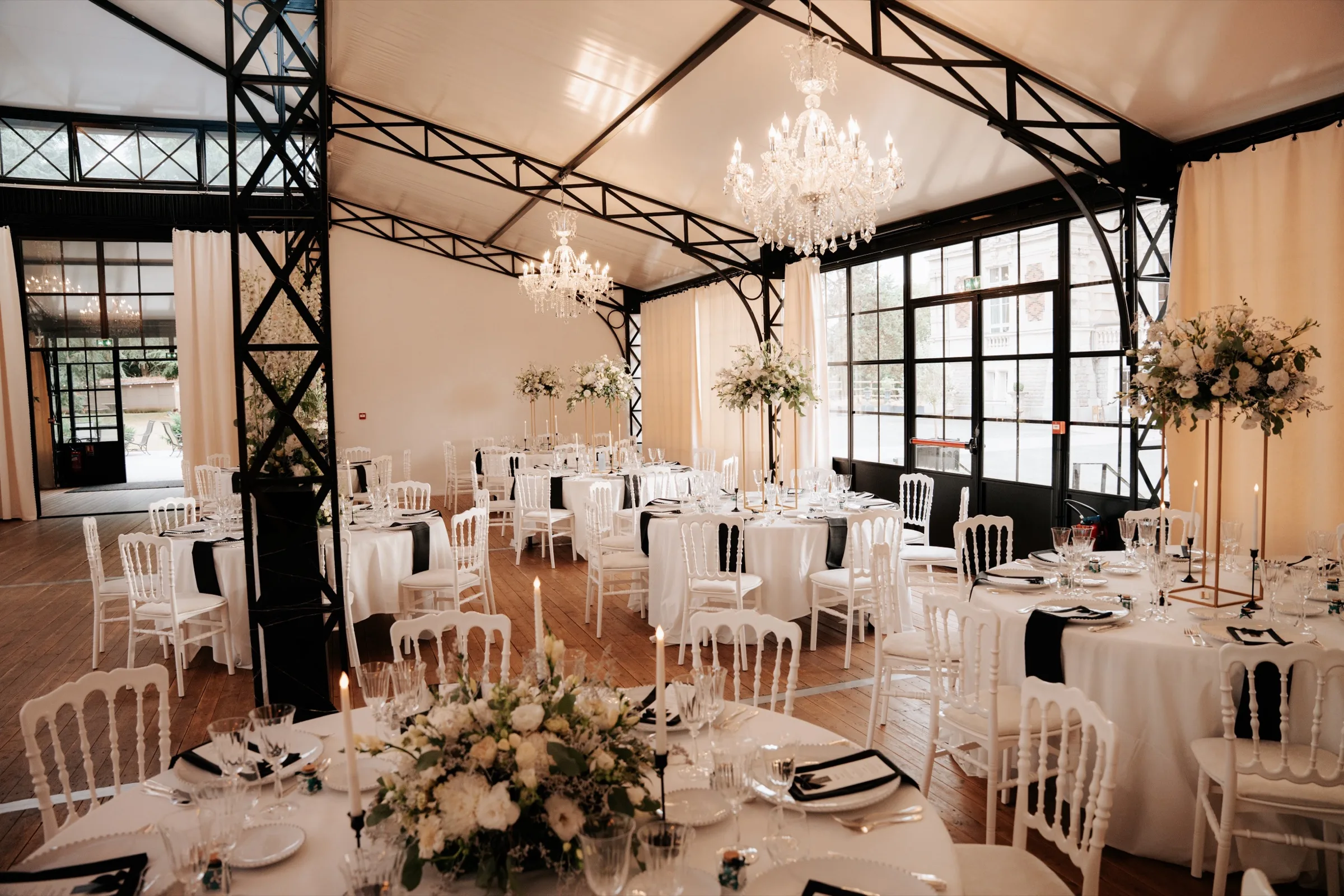 Salle de réception sous verrière, lustres de cristal et tables dressées