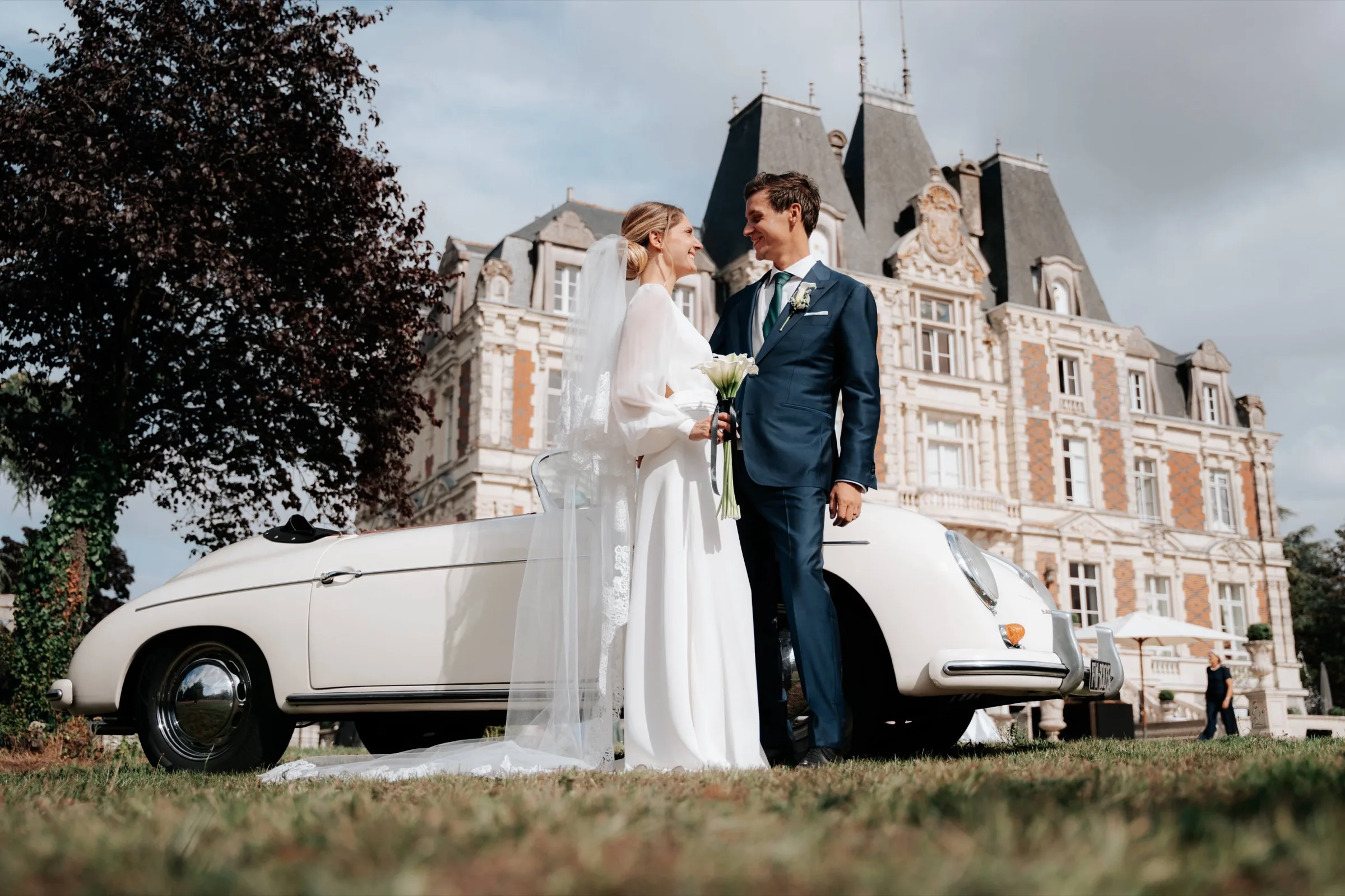 Les mariés devant une voiture ancienne, le château en arrière-plan