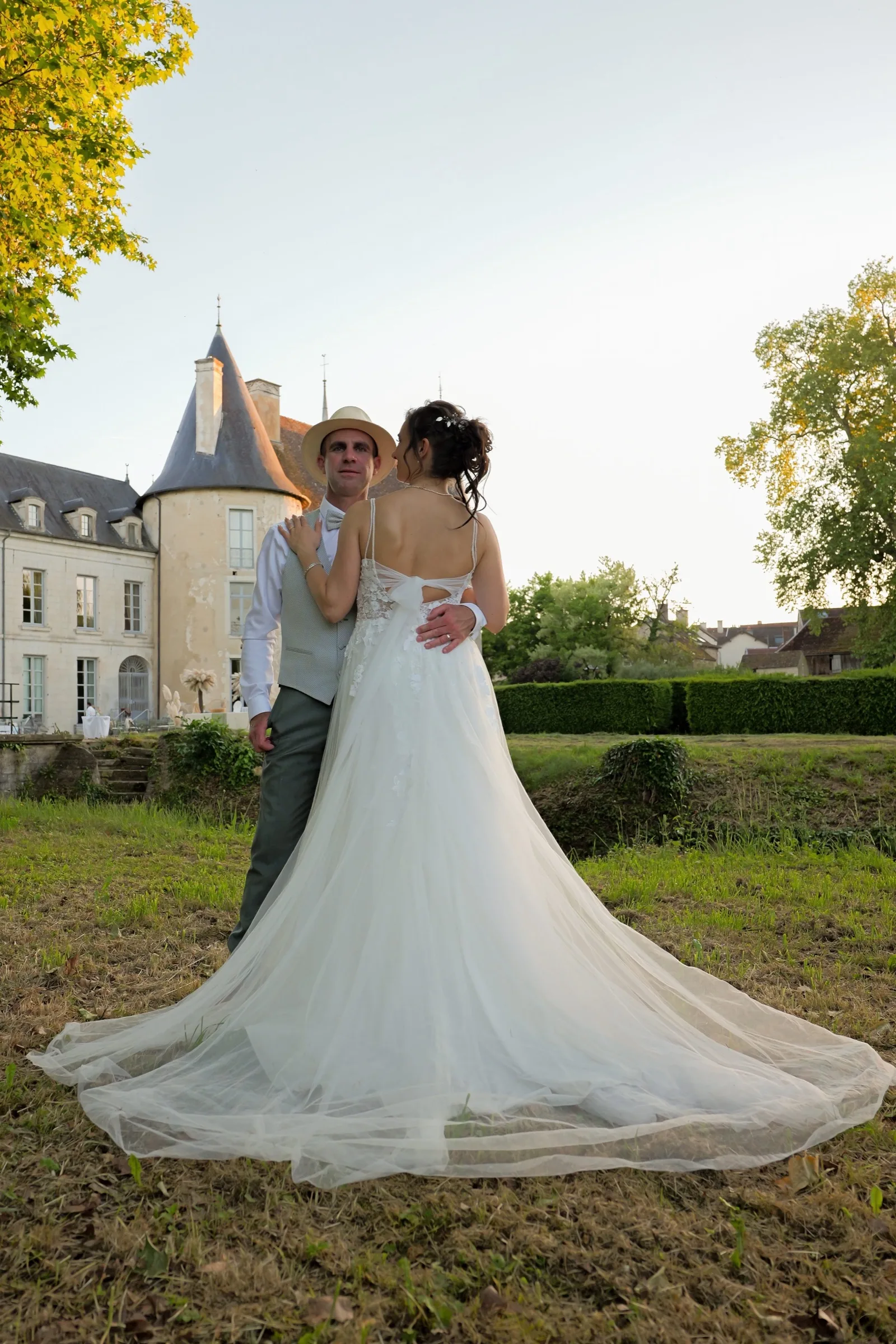 La mariée devant le château, sa traîne sur la pelouse