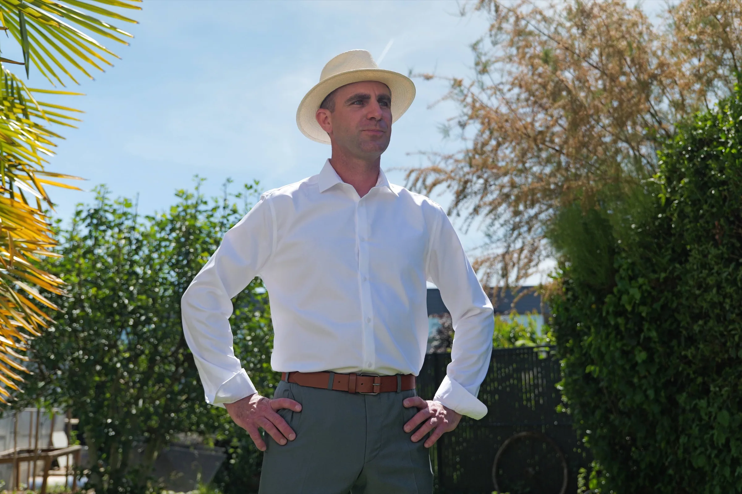 Le marié en chemise blanche et chapeau de paille