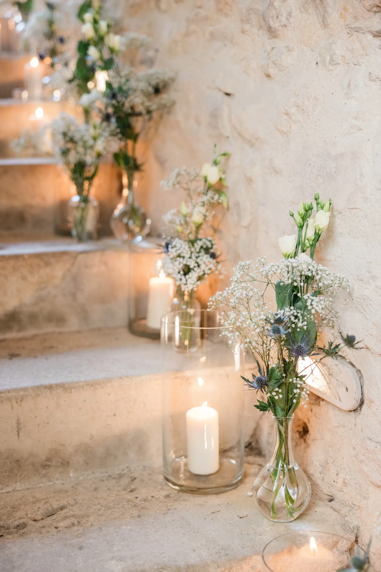 Escalier de pierre du château éclairé de bougies et de bouquets blancs