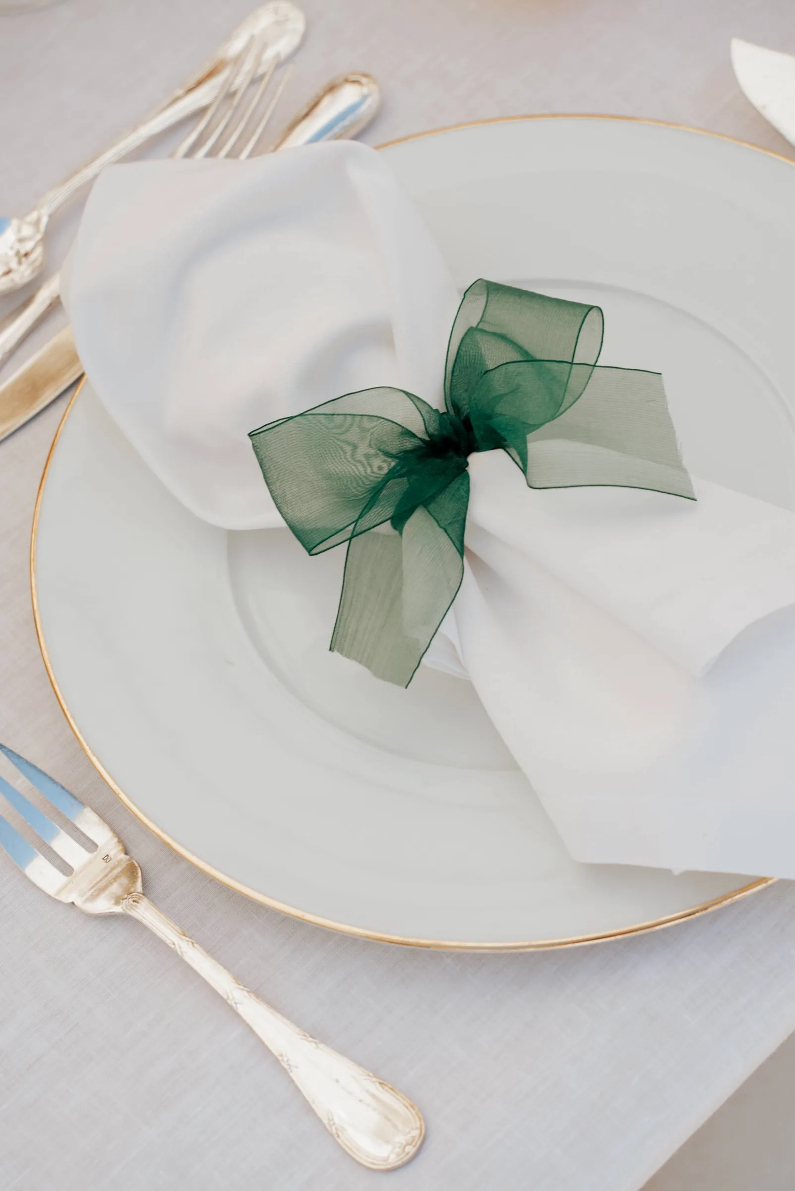 Assiette et serviette nouée d’un ruban vert