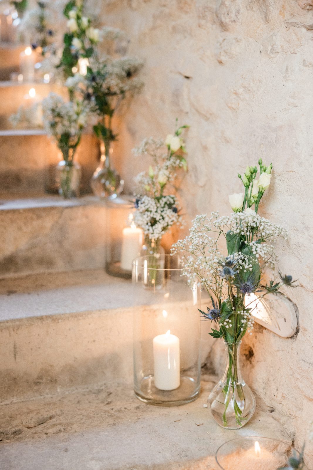 Escalier de pierre éclairé de bougies et de fleurs blanches