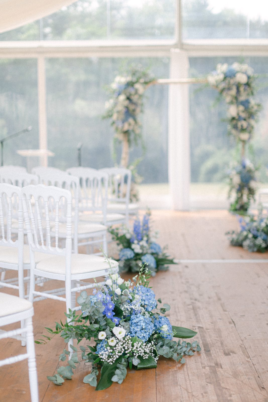 Allée de cérémonie sous verrière, compositions de fleurs bleues
